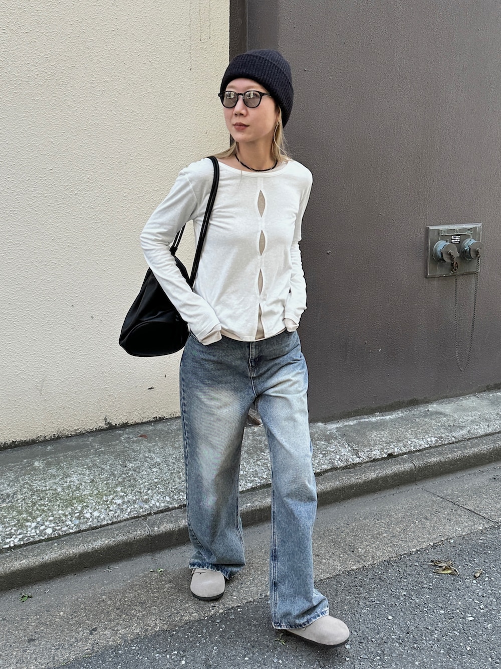 ホワイト系のTシャツ/カットソー、ブルー系のデニムパンツ、ブラック系のショルダーバッグを着用したレディースの春コーディネートの3枚目の写真
