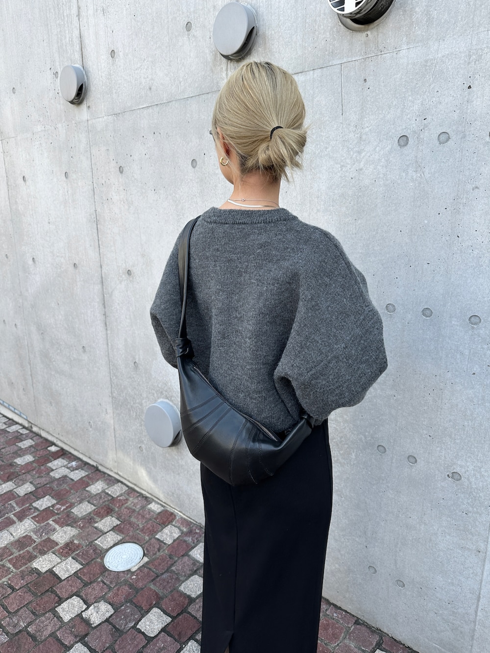 グレー系のニット/セーター、ブラック系のワンピース、ブラック系のショルダーバッグを着用したレディースの秋コーディネートの5枚目の写真