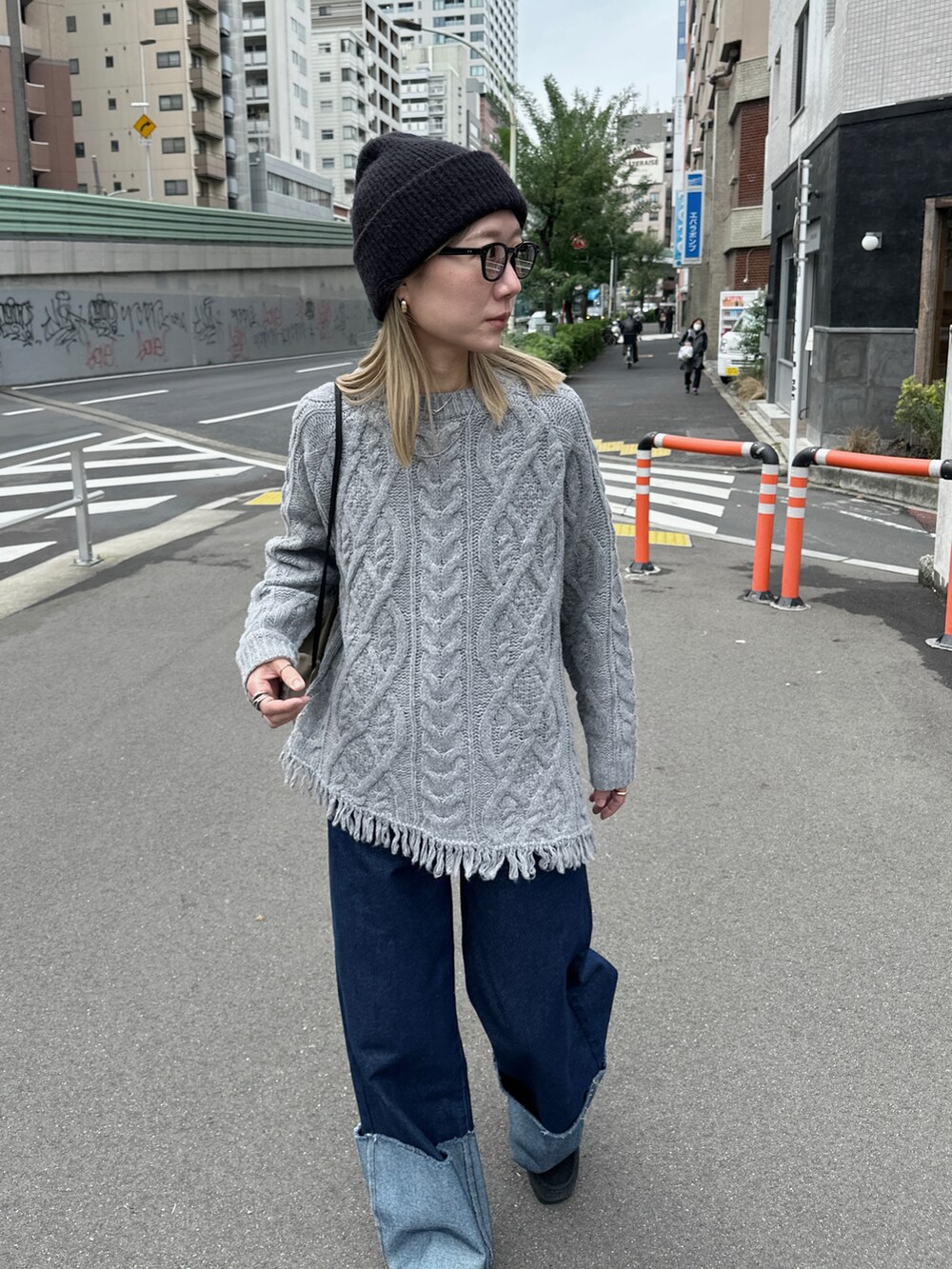 グレー系のニット/セーター、ブルー系のデニムパンツ、グリーン系のバックパック/リュックを着用したレディースの秋コーディネートの2枚目の写真