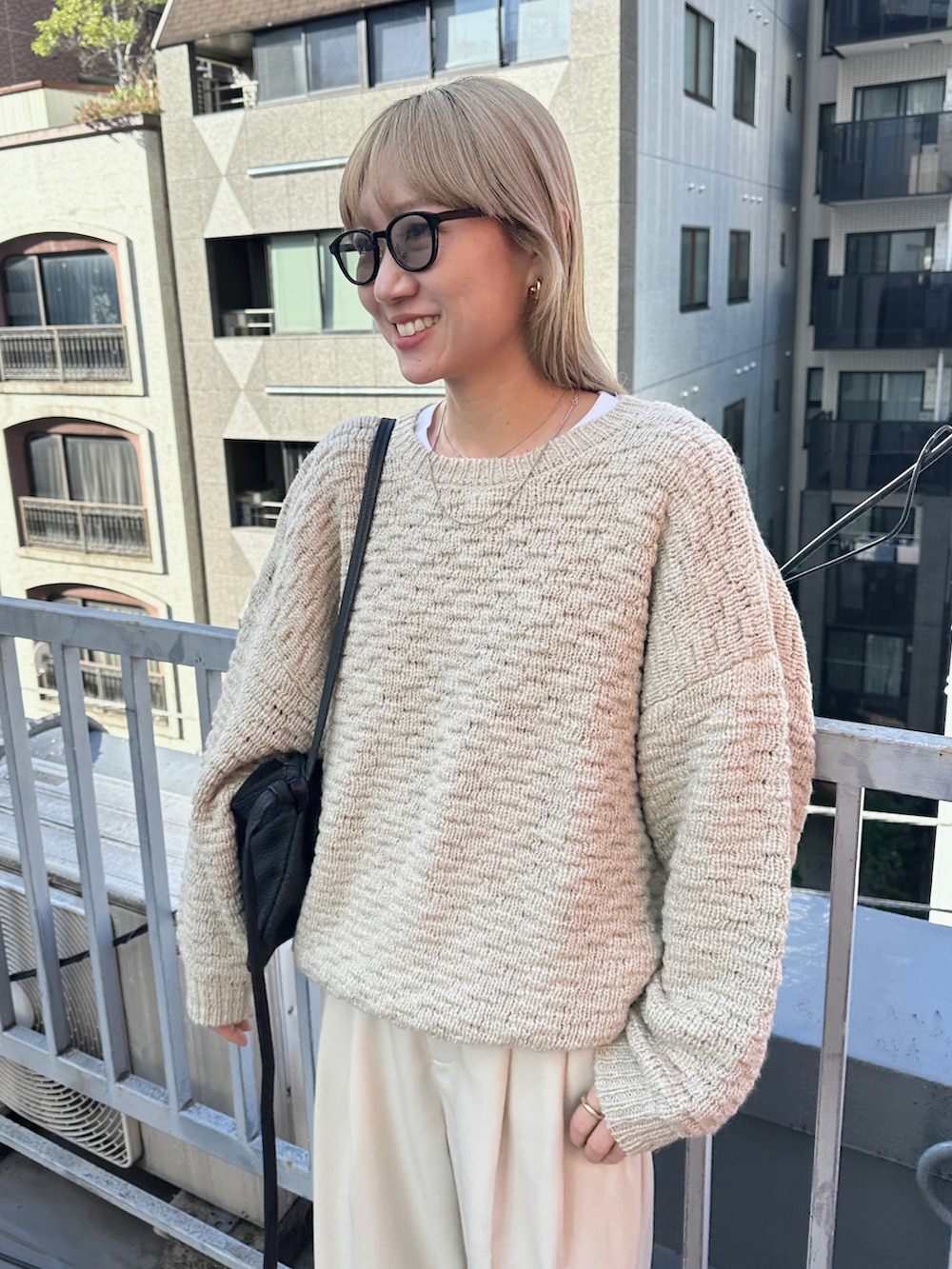 ベージュ系のニット/セーター、ホワイト系のスラックス、ブラック系のスリッポンを着用したレディースの冬コーディネートの3枚目の写真