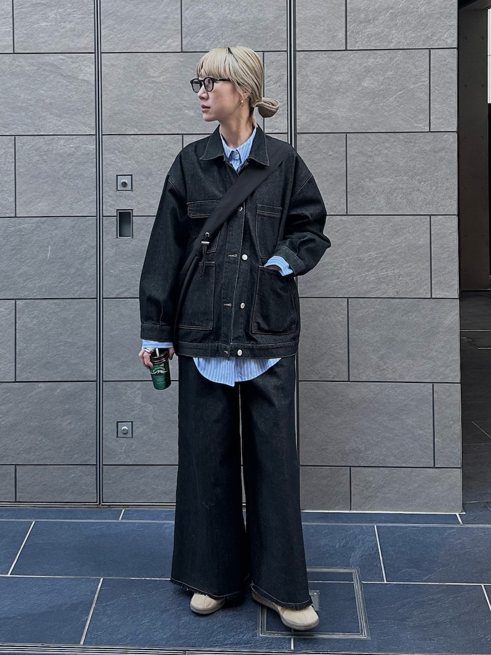 ブラック系のデニムジャケット、ブラック系のデニムパンツ、ブルー系のシャツ/ブラウスを着用したレディースの秋コーディネートの3枚目の写真