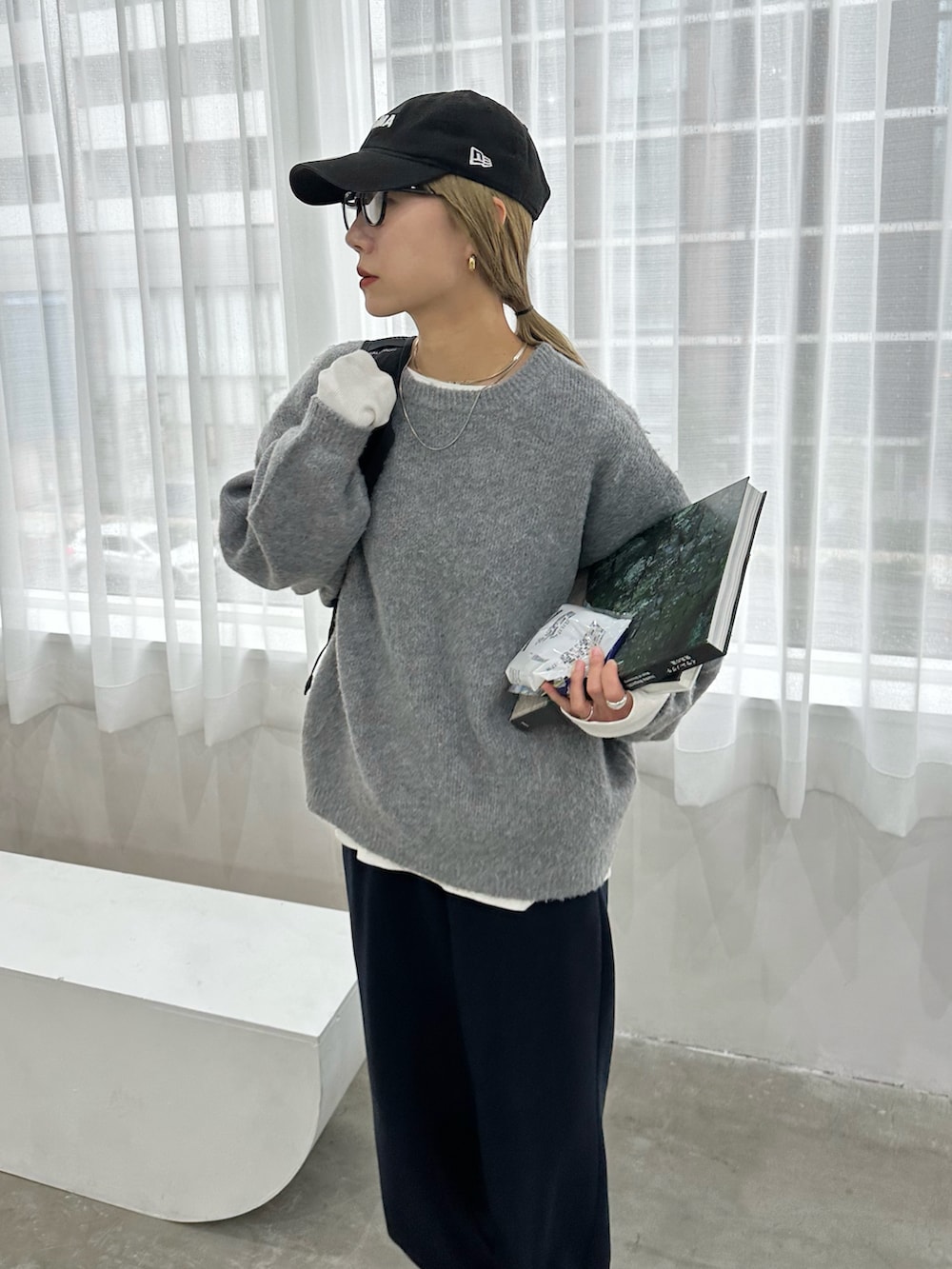 グレー系のニット/セーター、ホワイト系のTシャツ/カットソー、ブルー系のスウェットパンツを着用したレディースの秋コーディネートの4枚目の写真