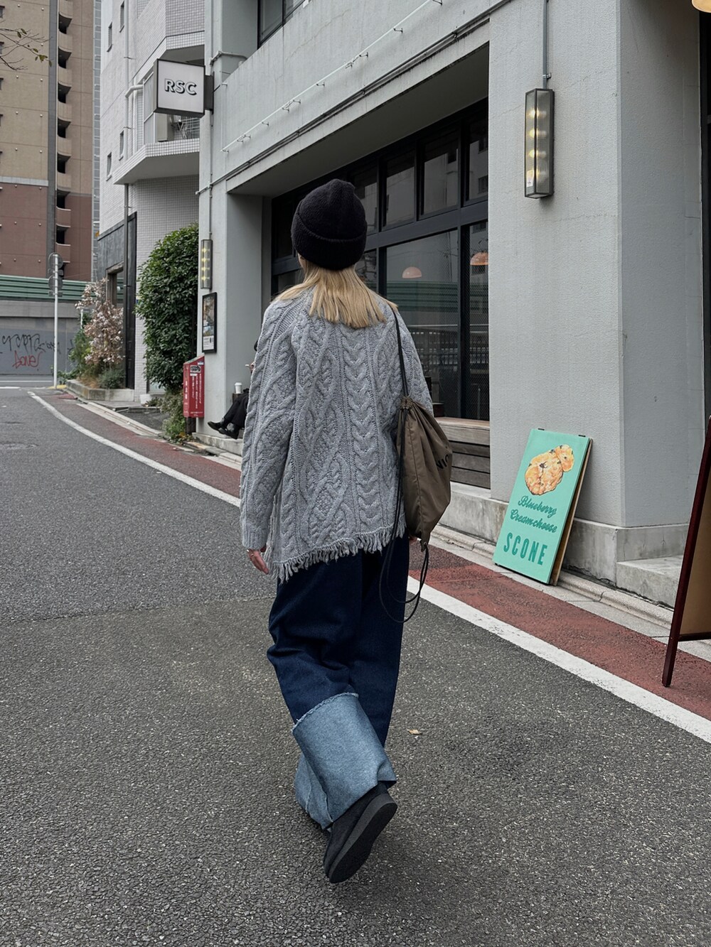 グレー系のニット/セーター、ブルー系のデニムパンツ、グリーン系のバックパック/リュックを着用したレディースの秋コーディネートの3枚目の写真