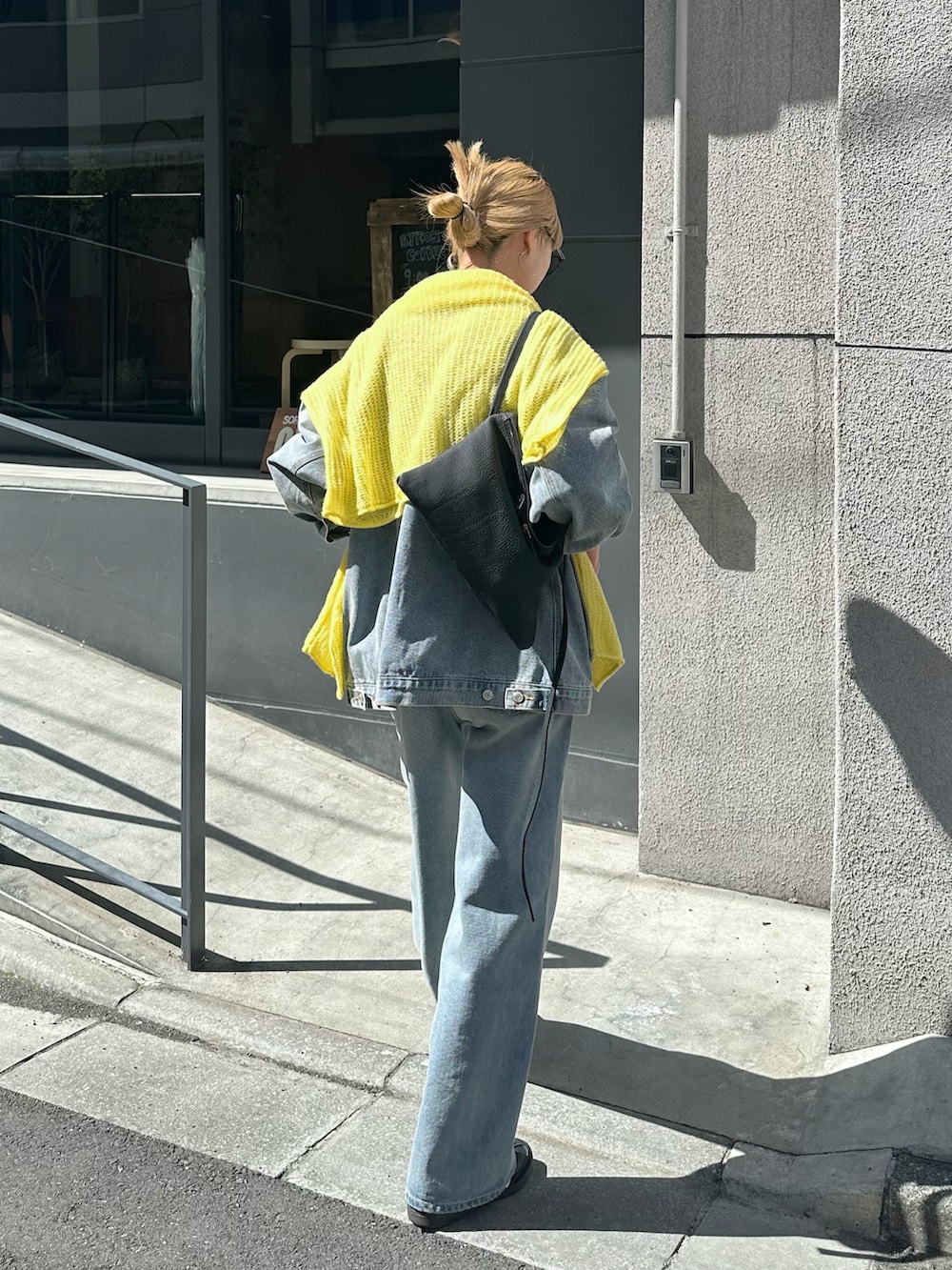 ブルー系のデニムジャケット、ブルー系のデニムパンツ、イエロー系のニット/セーターを着用したレディースの春コーディネートの3枚目の写真