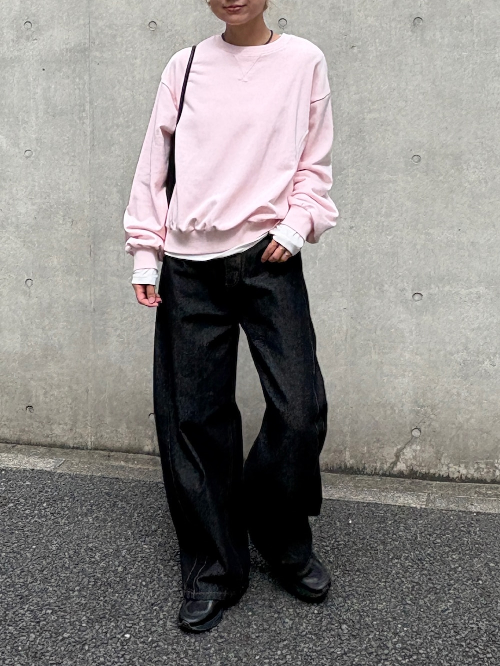 ピンク系のスウェット、ホワイト系のTシャツ/カットソー、ブラック系のデニムパンツを着用したレディースの秋コーディネートの2枚目の写真