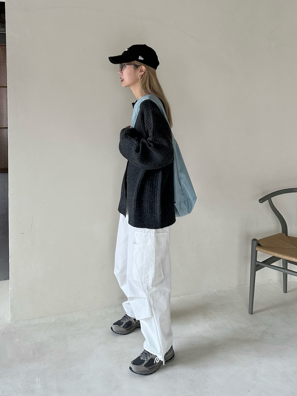 ブラック系のカーディガン/ボレロ、ホワイト系のカーゴパンツ、ブルー系のショルダーバッグを着用したレディースの秋コーディネートの3枚目の写真