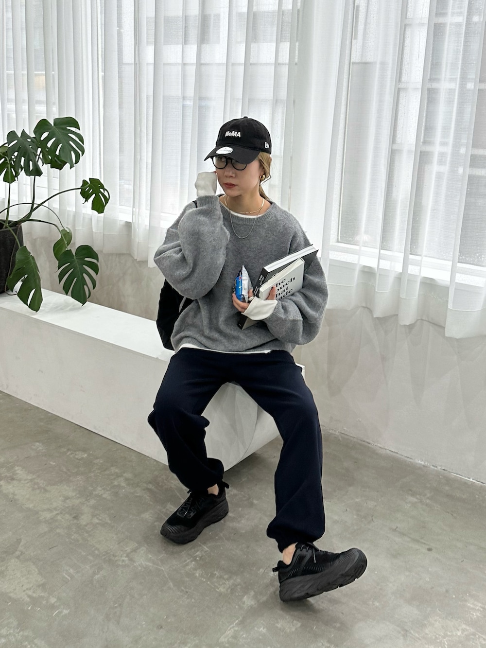 グレー系のニット/セーター、ホワイト系のTシャツ/カットソー、ブルー系のスウェットパンツを着用したレディースの秋コーディネートの3枚目の写真