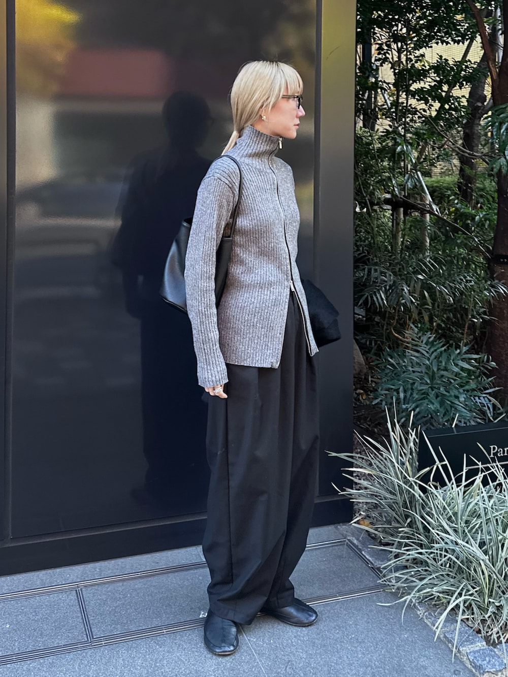 グレー系のニット/セーター、ブラック系のスラックス、ブラック系のバレエシューズを着用したレディースの冬コーディネートの2枚目の写真