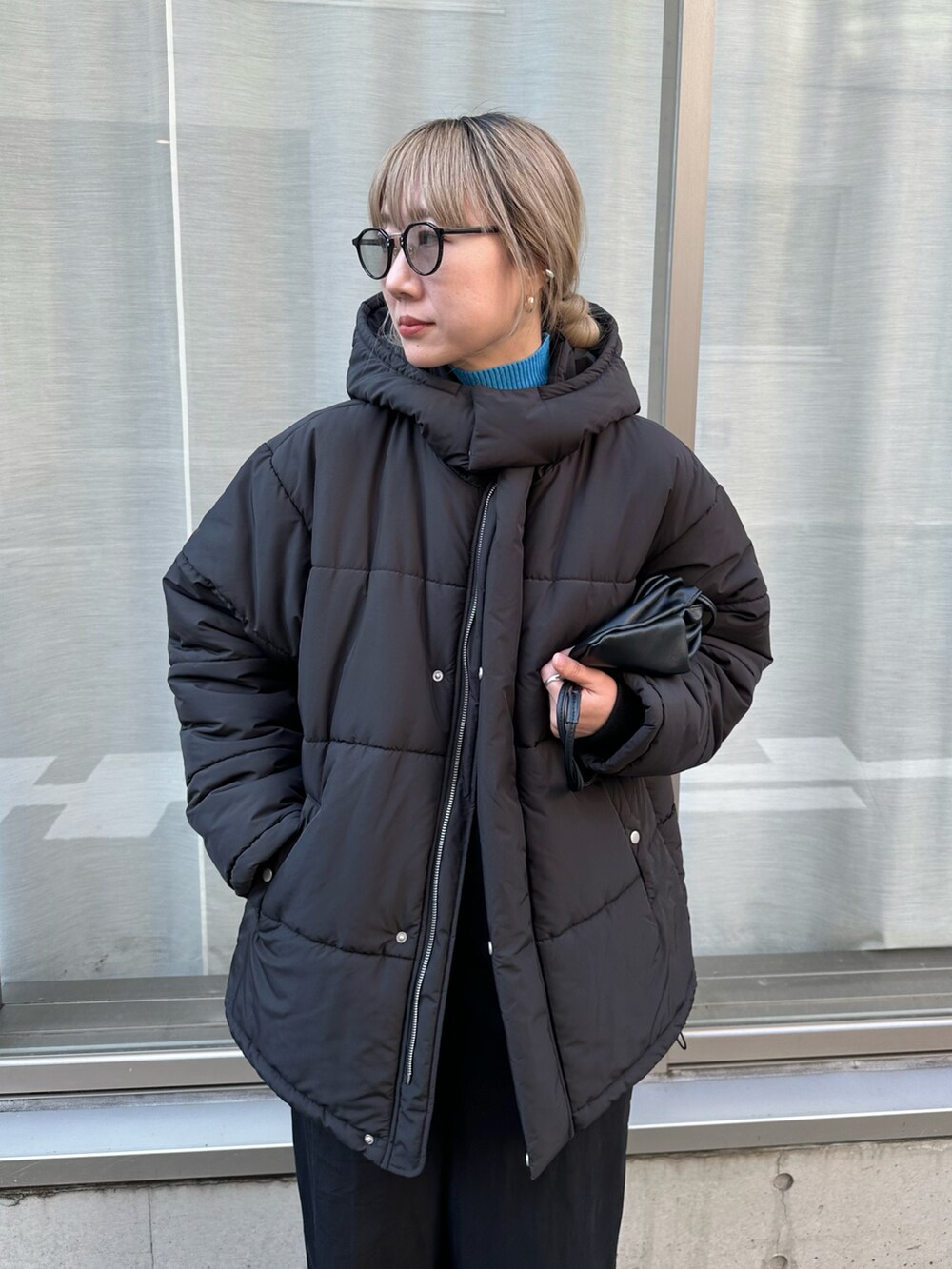 ブラック系のダウンジャケット/コート、ブルー系のニット/セーター、ブラック系のサロペット/オーバーオールを着用したレディースの秋コーディネートの5枚目の写真