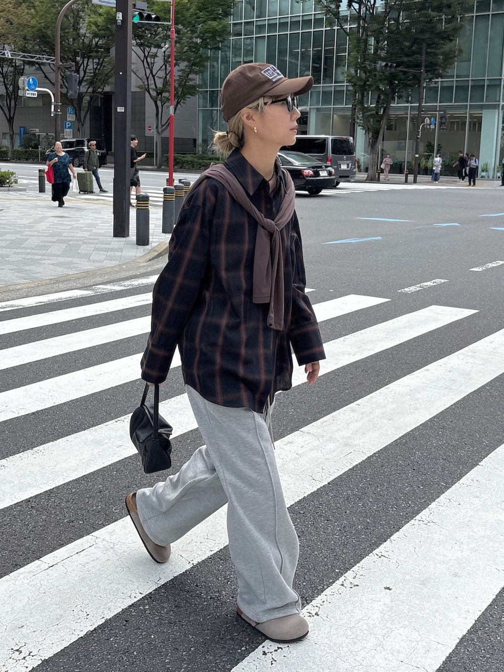 グレー系のスウェットパンツ、ブラック系のショルダーバッグ、ブルー系のシャツ/ブラウスを着用したレディースの秋コーディネートの2枚目の写真