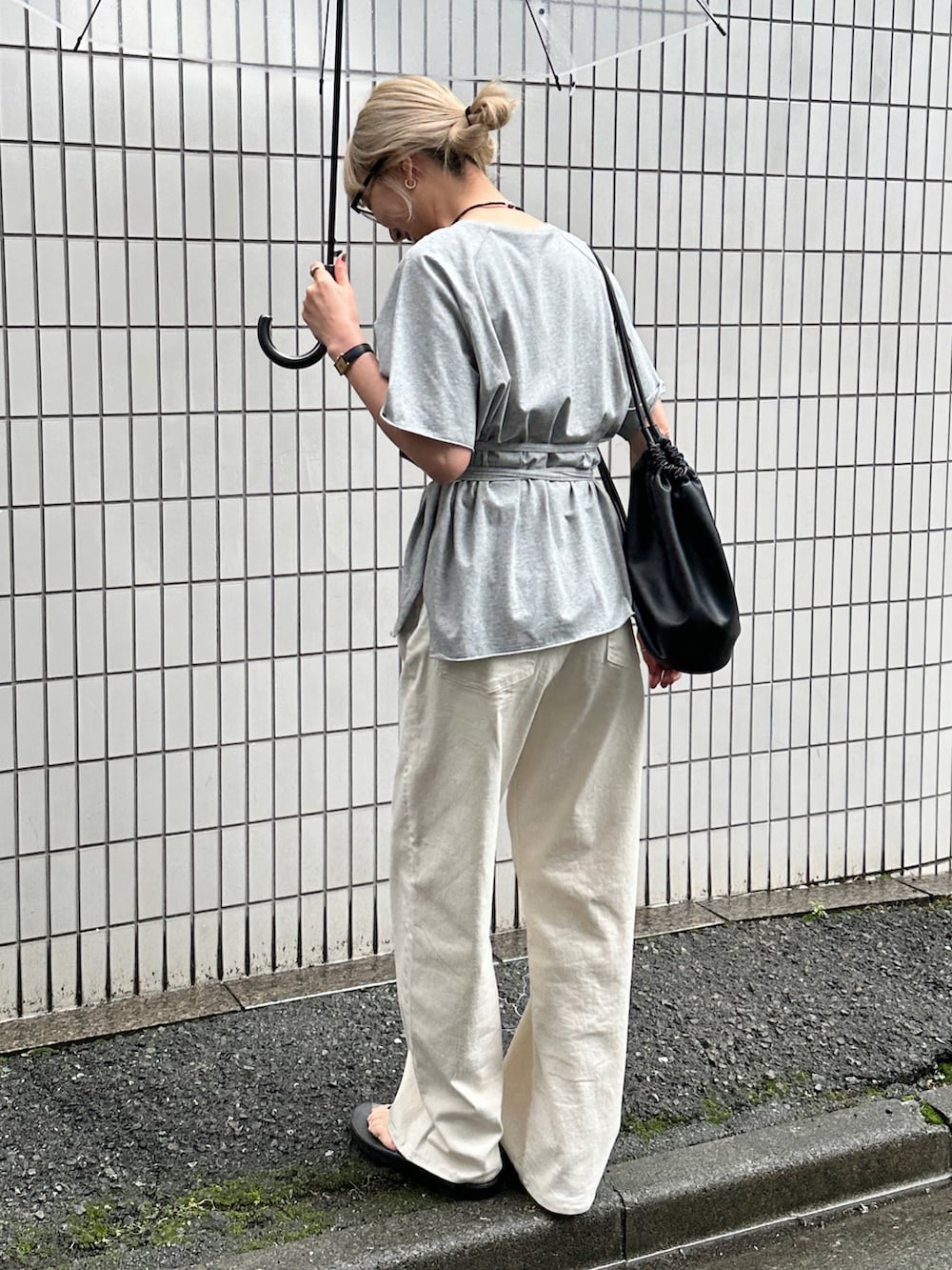 グレー系のTシャツ/カットソー、ホワイト系のデニムパンツ、ブラック系のショルダーバッグを着用したレディースの夏コーディネートの2枚目の写真