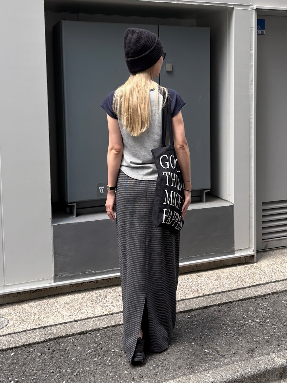 グレー系のスカート、ブルー系のTシャツ/カットソー、ブラック系のトートバッグを着用したレディースの夏コーディネートの3枚目の写真