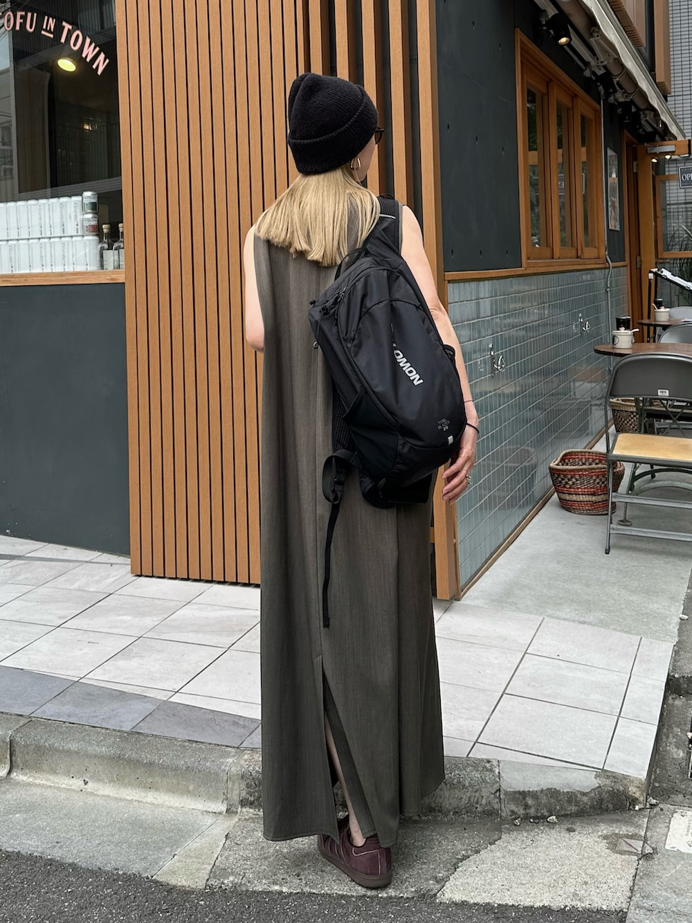 グレー系のワンピース、ブラウン系のスニーカー、ブラック系のバックパック/リュックを着用したレディースの春コーディネートの2枚目の写真