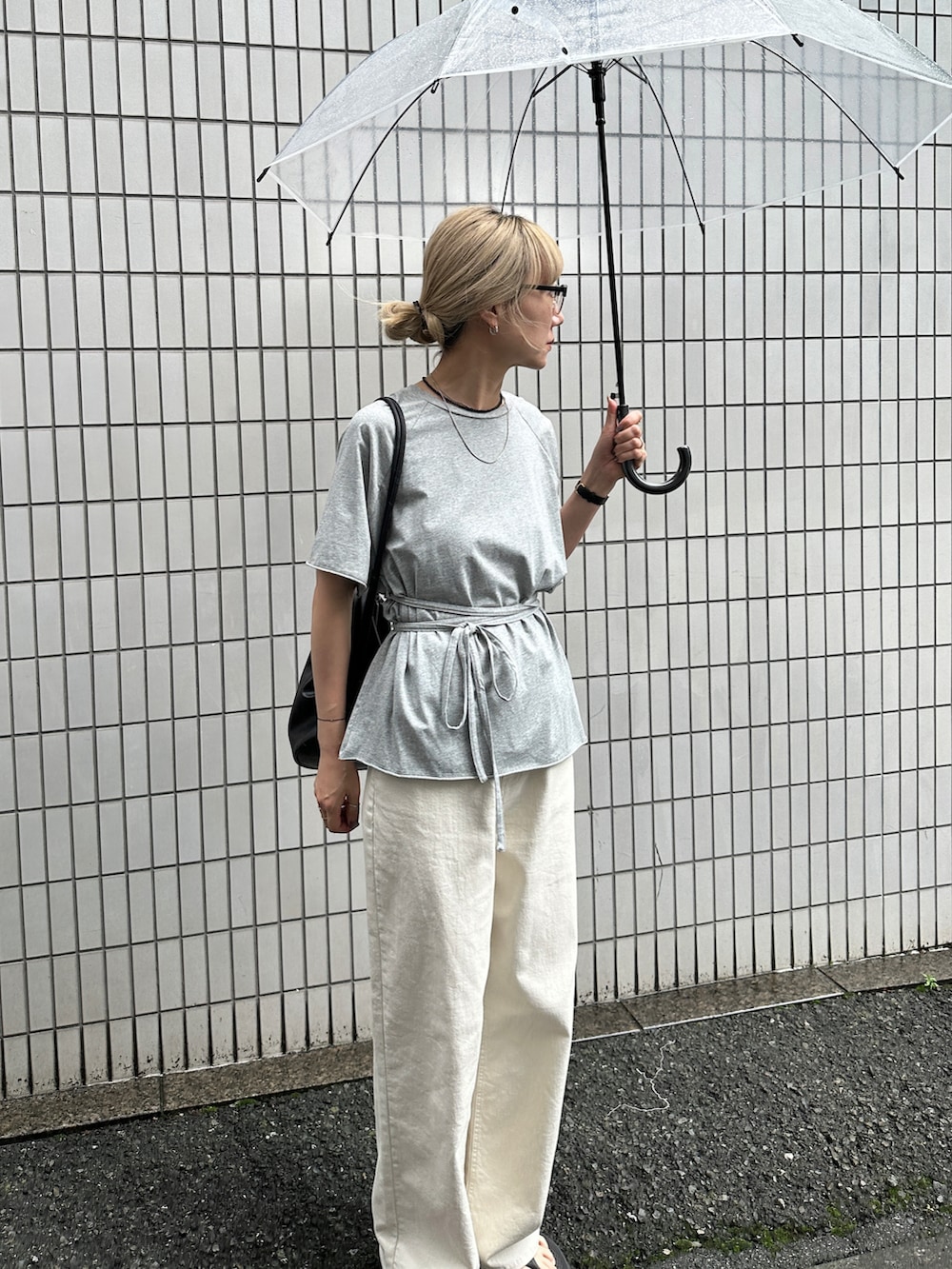 グレー系のTシャツ/カットソー、ホワイト系のデニムパンツ、ブラック系のショルダーバッグを着用したレディースの夏コーディネートの3枚目の写真