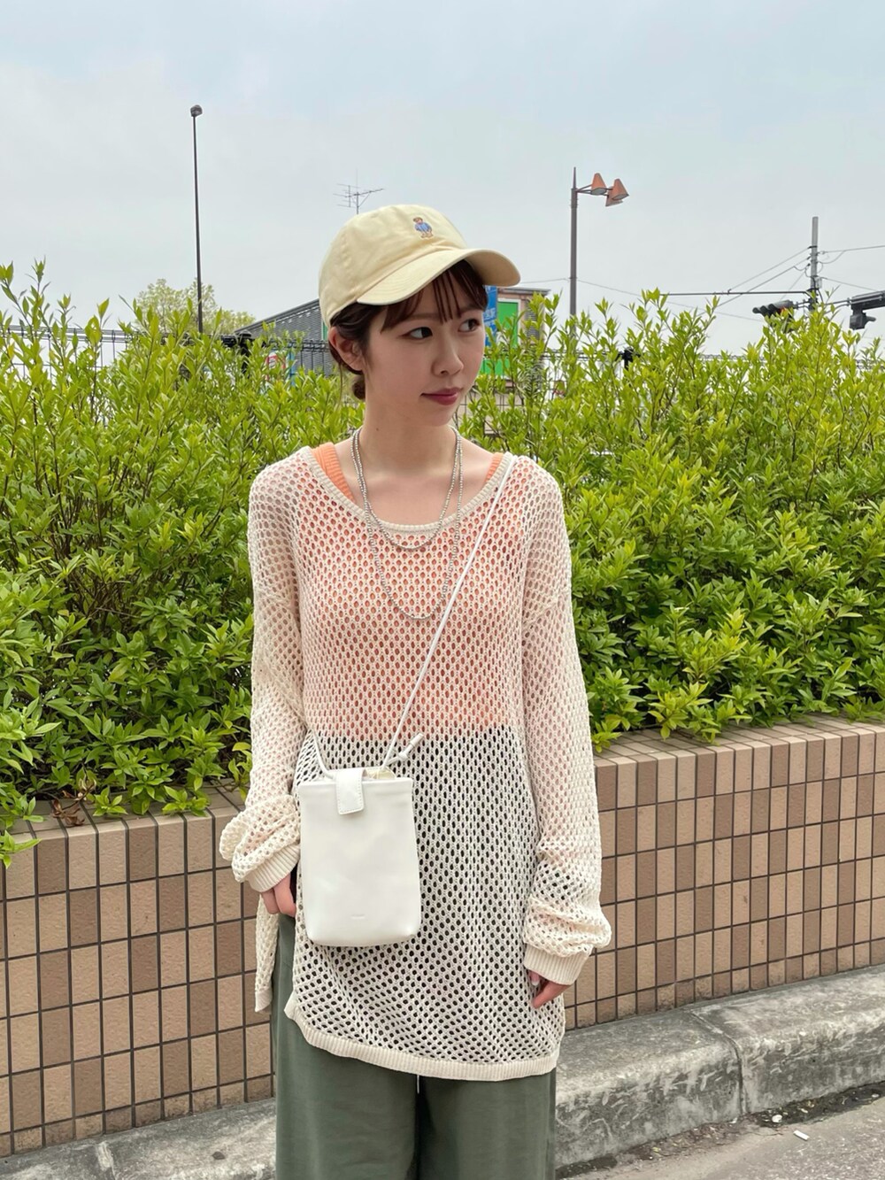 ホワイト系のニット/セーター、グリーン系のその他パンツ、レッド系のスニーカーを着用したレディースの春コーディネートの3枚目の写真