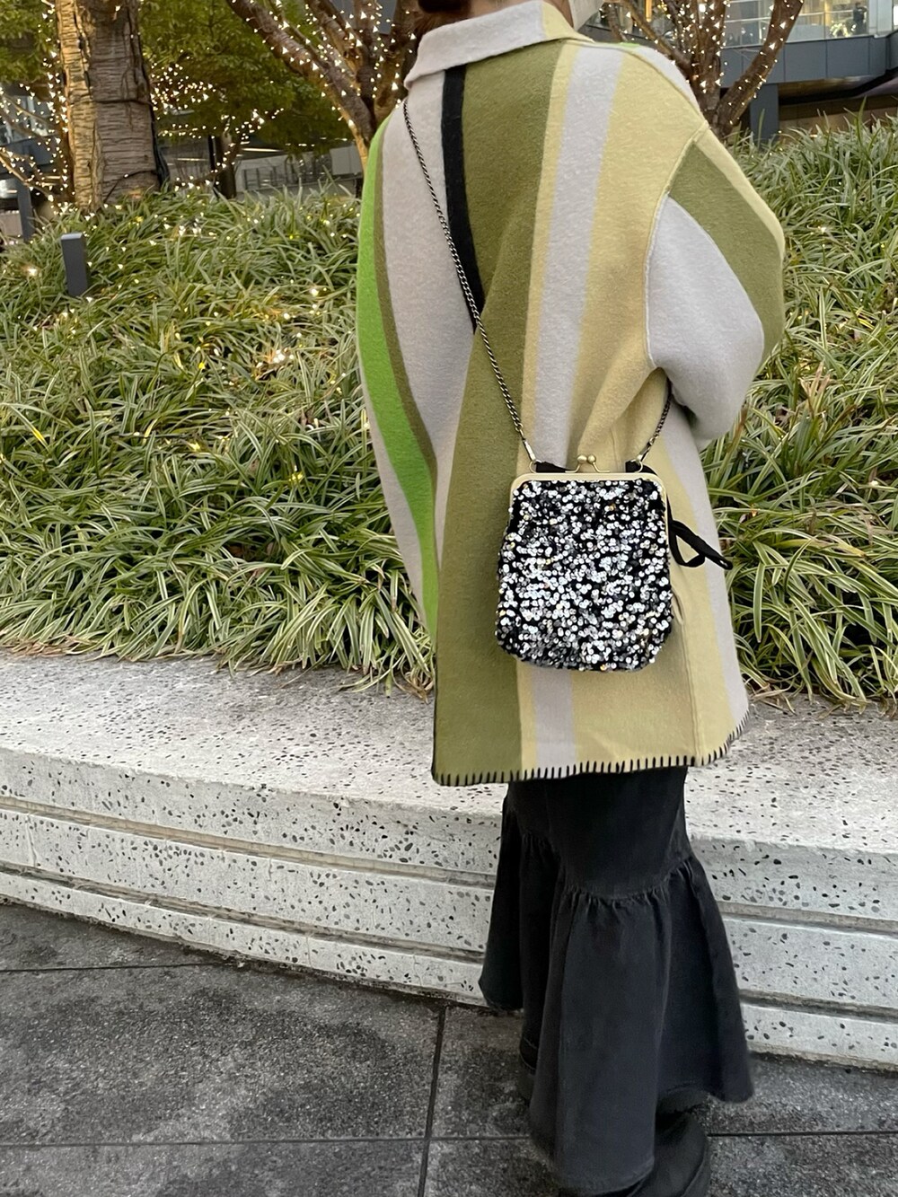 イエロー系のその他アウター、ブラック系のショルダーバッグ、ブラック系のデニムスカートを着用したレディースの冬コーディネートの2枚目の写真