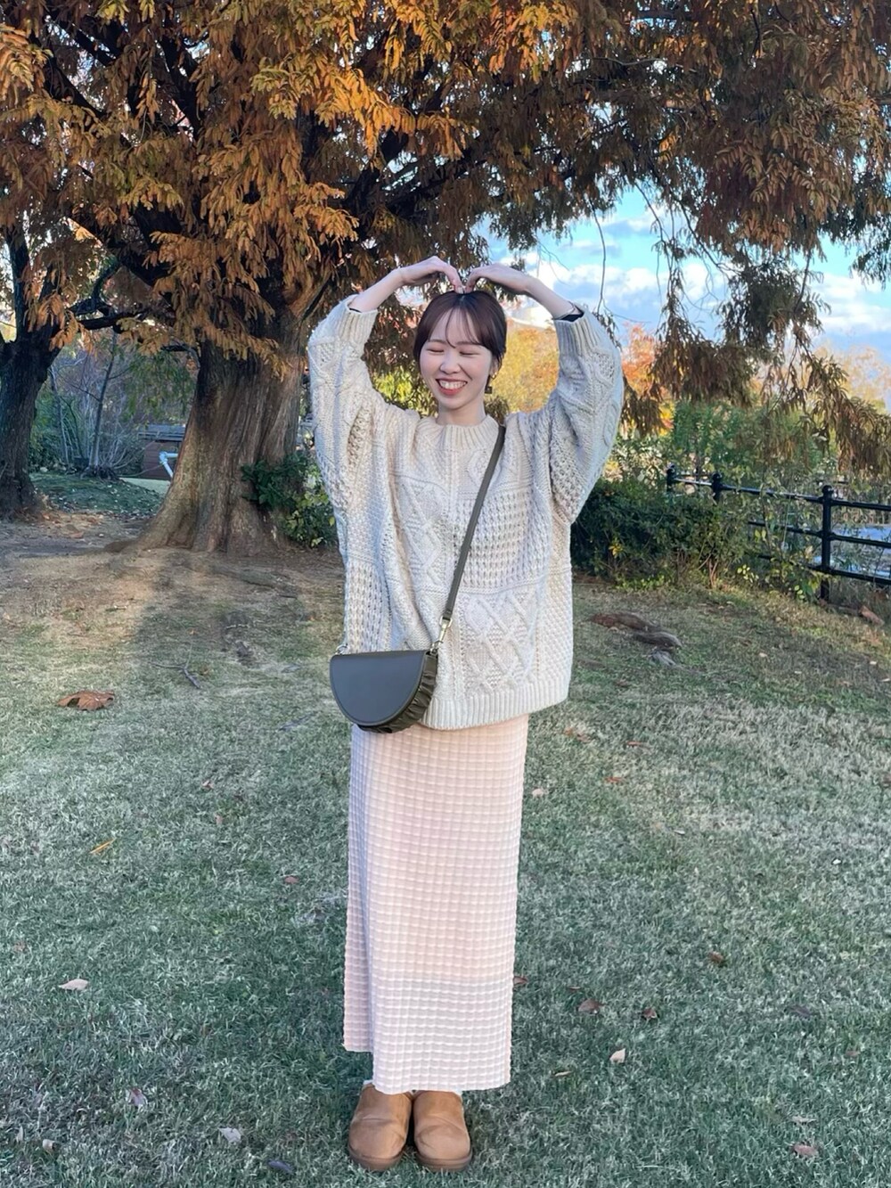 イエロー系のスリッポン、オレンジ系のスカート、ホワイト系のニット/セーターを着用したレディースの冬コーディネートの3枚目の写真