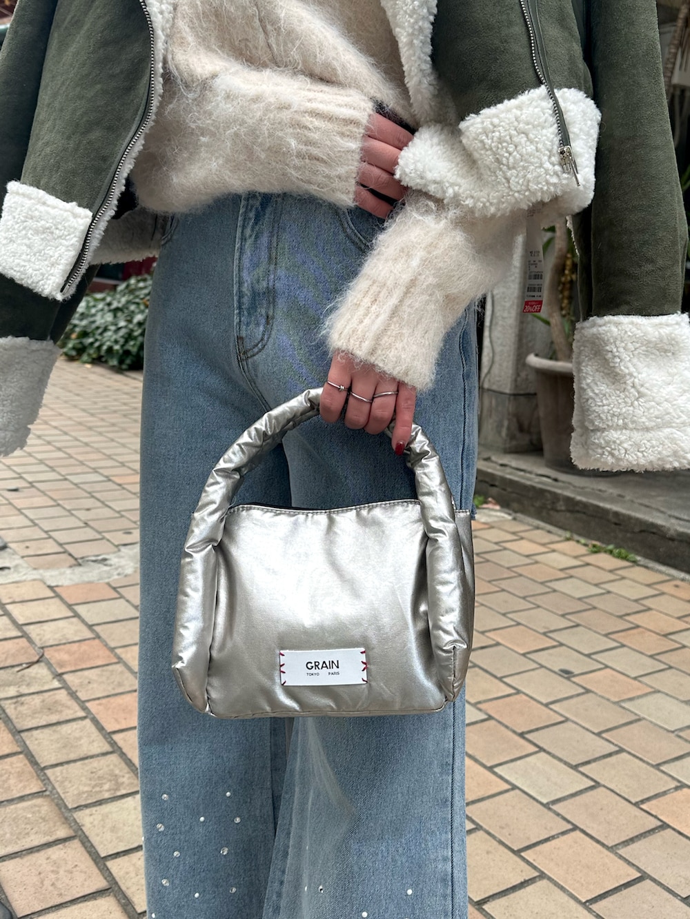 ブルー系のデニムパンツ、ホワイト系のムートンコート、ホワイト系のニット/セーターを着用したレディースの冬コーディネートの5枚目の写真