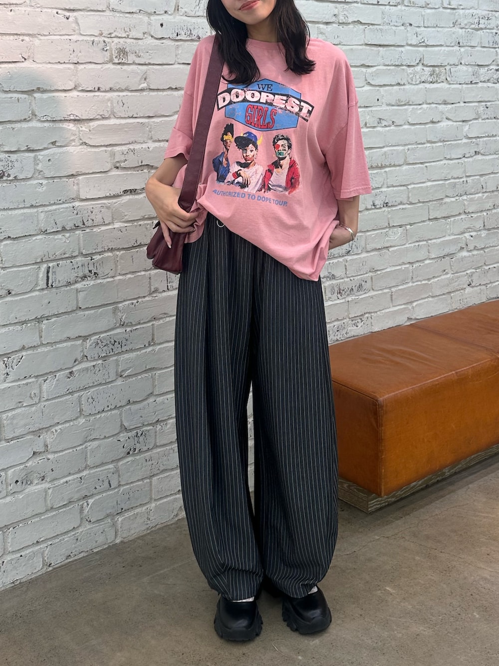 レッド系のTシャツ/カットソー、グレー系のスラックス、レッド系のトートバッグを着用したレディースの夏コーディネートの2枚目の写真