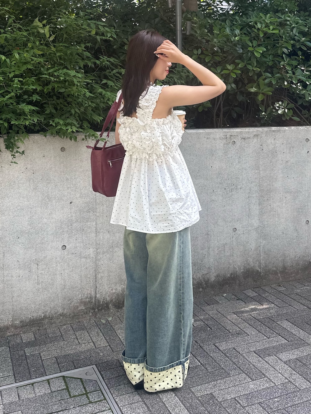 ブルー系のデニムパンツ、レッド系のトートバッグを着用したレディースの夏コーディネートの2枚目の写真