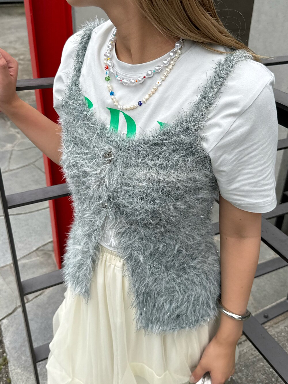 グリーン系のニット/セーターを着用したレディースの夏コーディネートの2枚目の写真