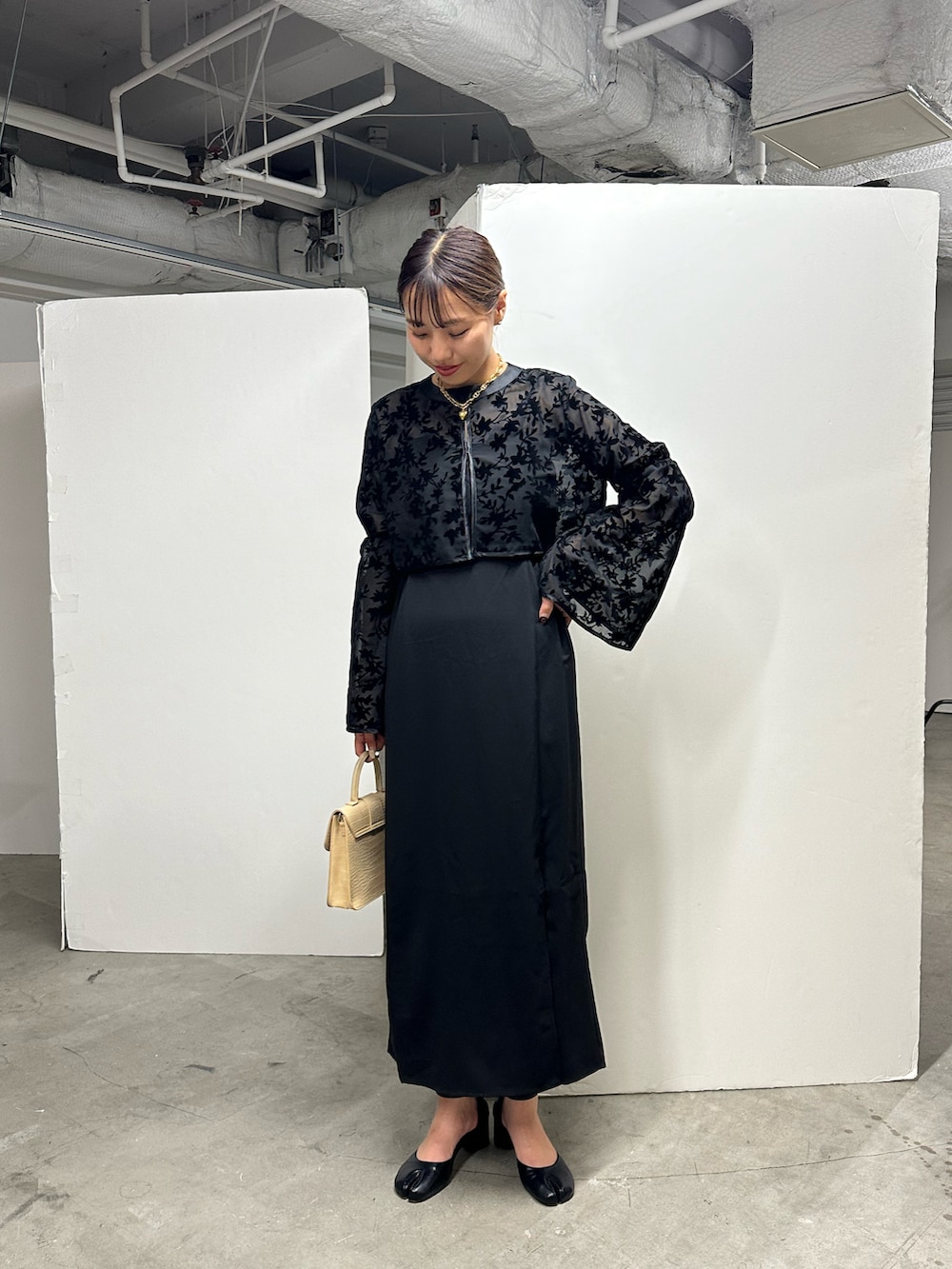 ブラック系のドレスを着用したレディースの秋コーディネートの2枚目の写真