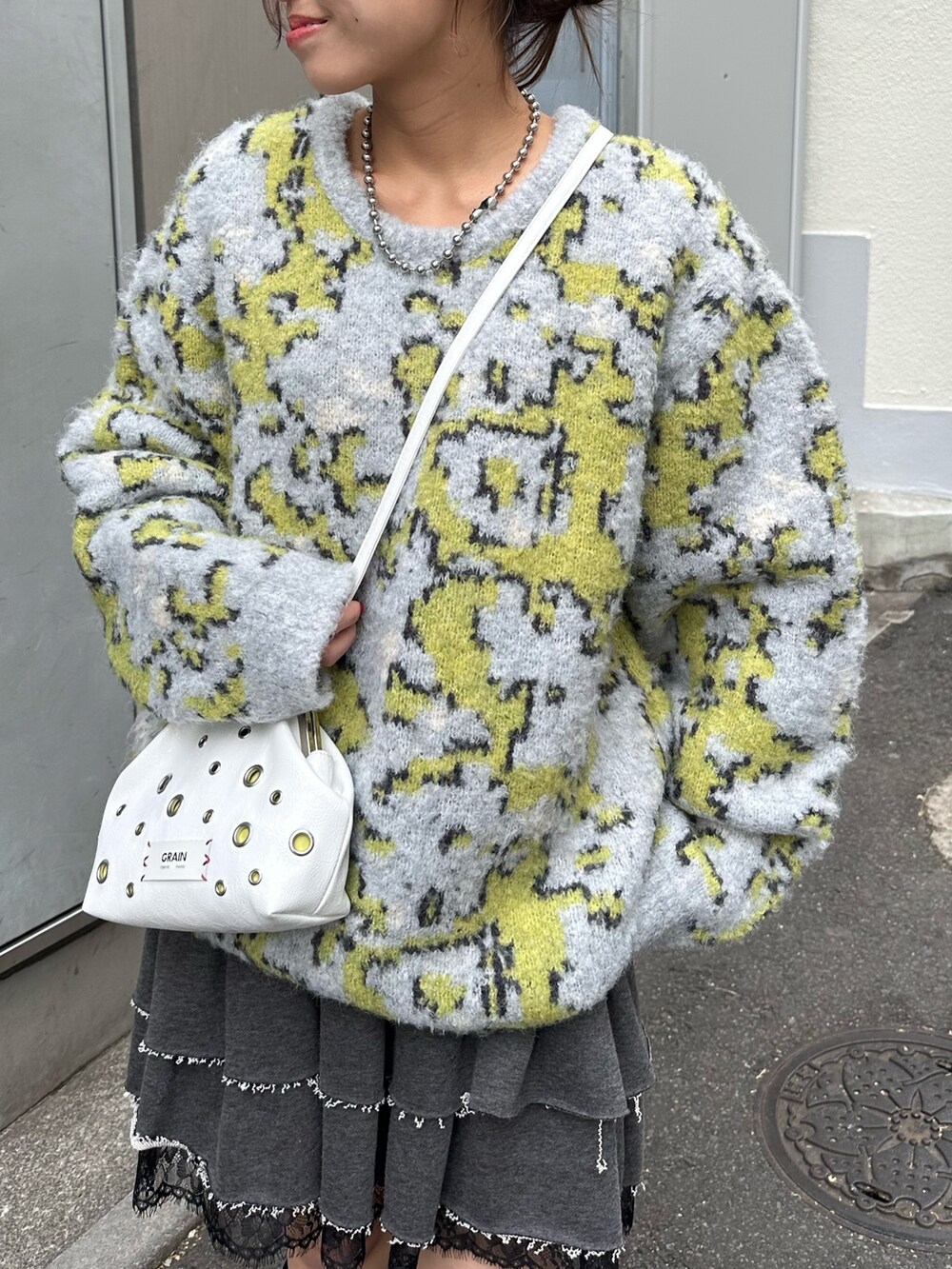 グレー系のニット/セーター、グレー系のスカートを着用したレディースの冬コーディネートの2枚目の写真