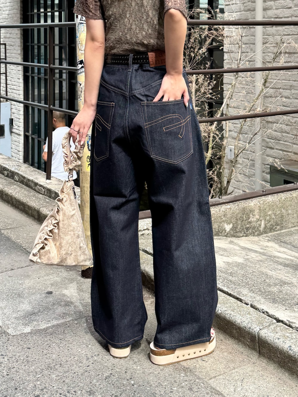 グリーン系のTシャツ/カットソー、ブルー系のデニムパンツ、ベージュ系のサンダルを着用したレディースの春コーディネートの3枚目の写真