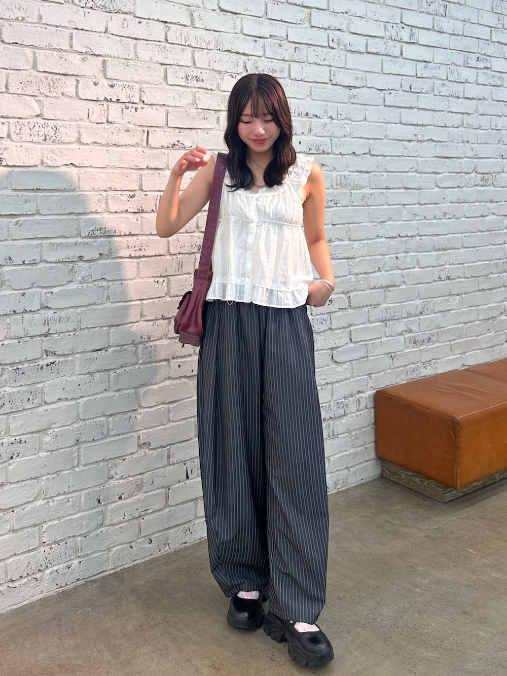 ホワイト系のシャツ/ブラウス、グレー系のスラックス、レッド系のトートバッグを着用したレディースの夏コーディネートの2枚目の写真