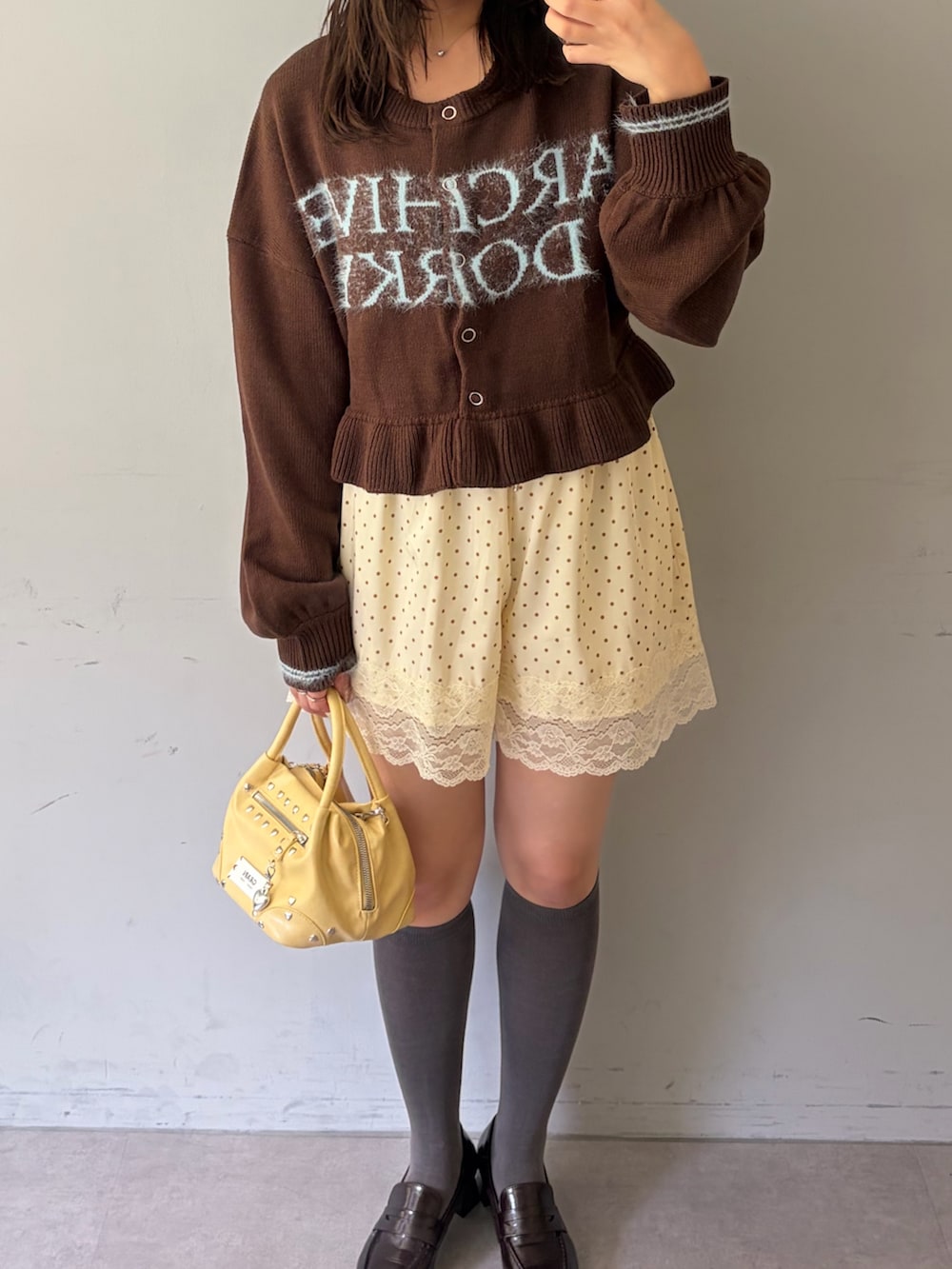 ブラウン系のカーディガン/ボレロ、ホワイト系のその他パンツ、イエロー系のショルダーバッグを着用したレディースの秋コーディネートの2枚目の写真
