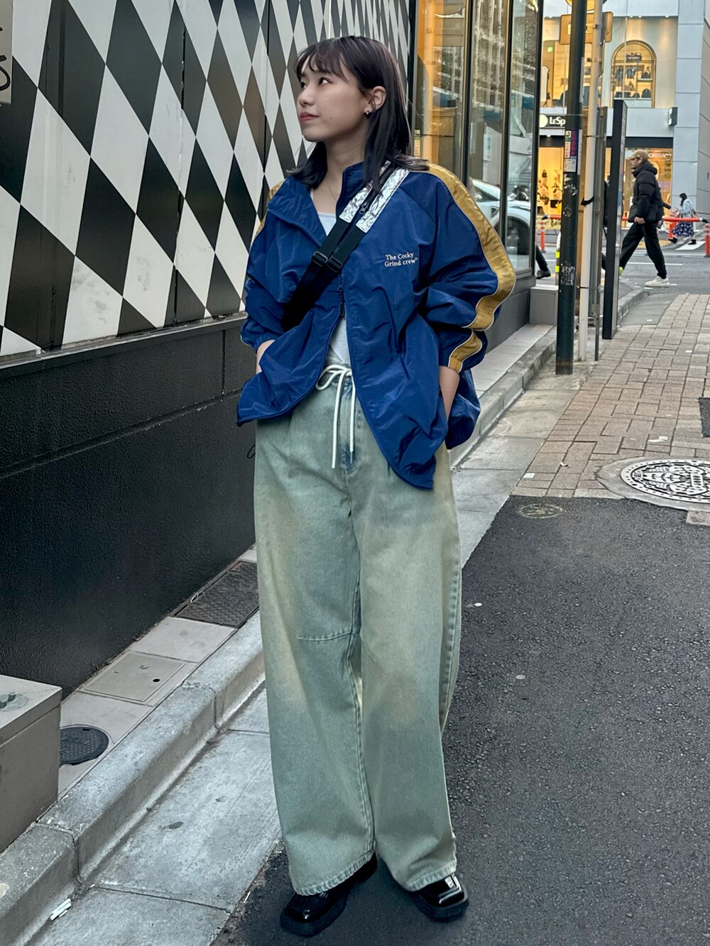 ブルー系のデニムパンツ、ブルー系のナイロンジャケットを着用したレディースの冬コーディネートの2枚目の写真