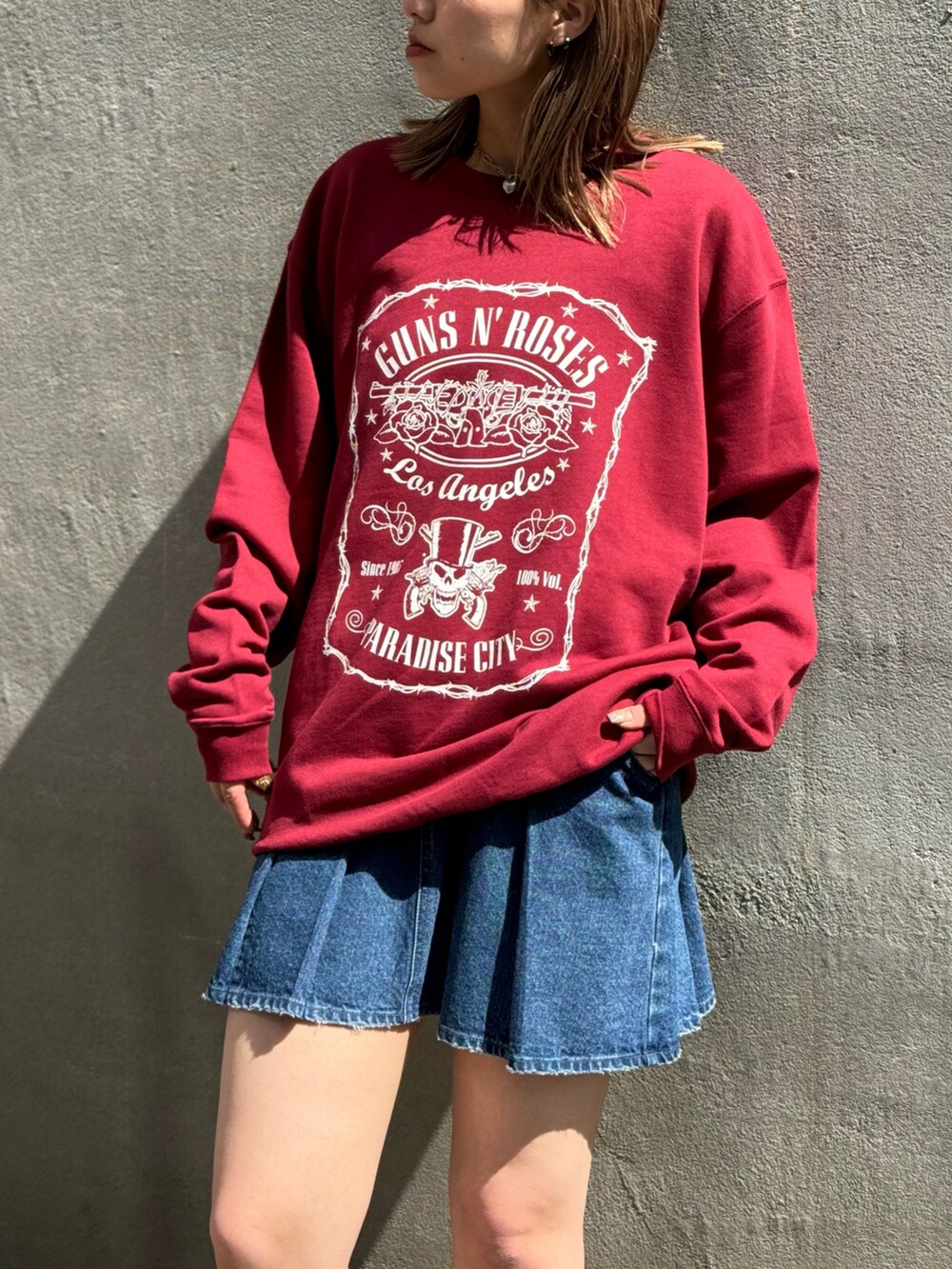 レッド系のスウェット、ブルー系のデニムスカートを着用したレディースの春コーディネートの3枚目の写真