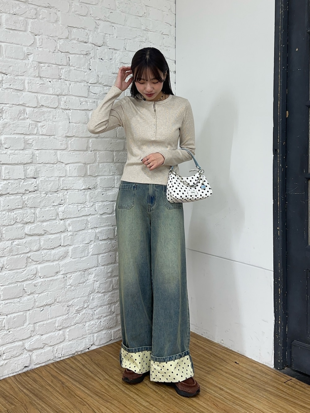 ブルー系のデニムパンツ、ホワイト系のトートバッグを着用したレディースの春コーディネートの2枚目の写真