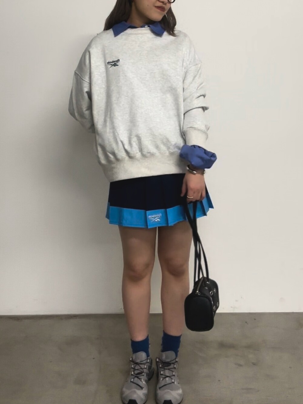 グレー系のトップス、ブルー系のシャツ/ブラウス、ブラック系のバッグを着用したレディースの春コーディネートの4枚目の写真