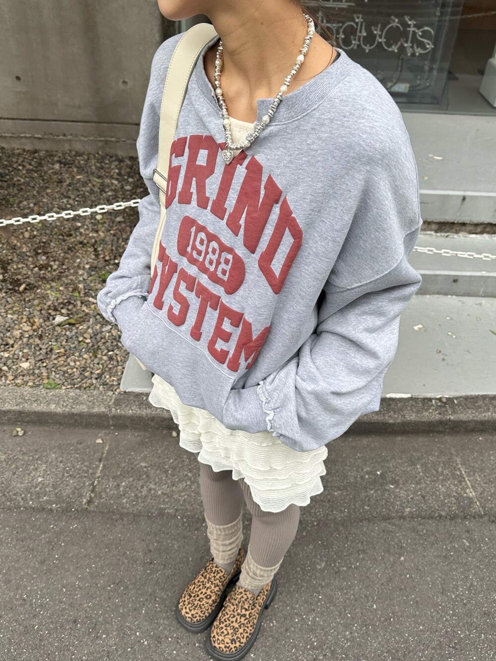 グレー系のスウェット、ホワイト系のその他パンツを着用したレディースの秋コーディネートの2枚目の写真