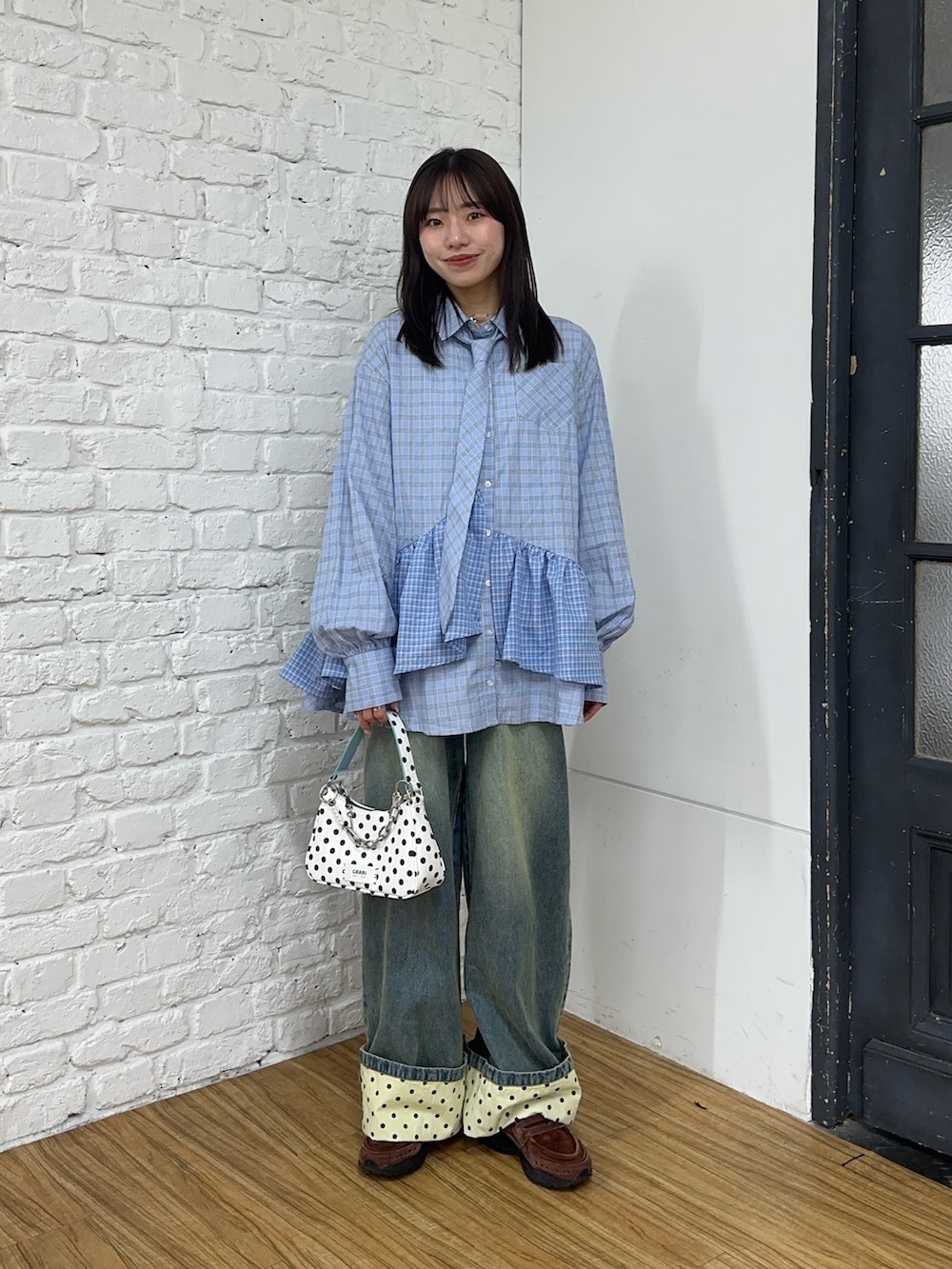 ブルー系のシャツ/ブラウス、ホワイト系のトートバッグ、ブルー系のデニムパンツを着用したレディースの春コーディネートの2枚目の写真