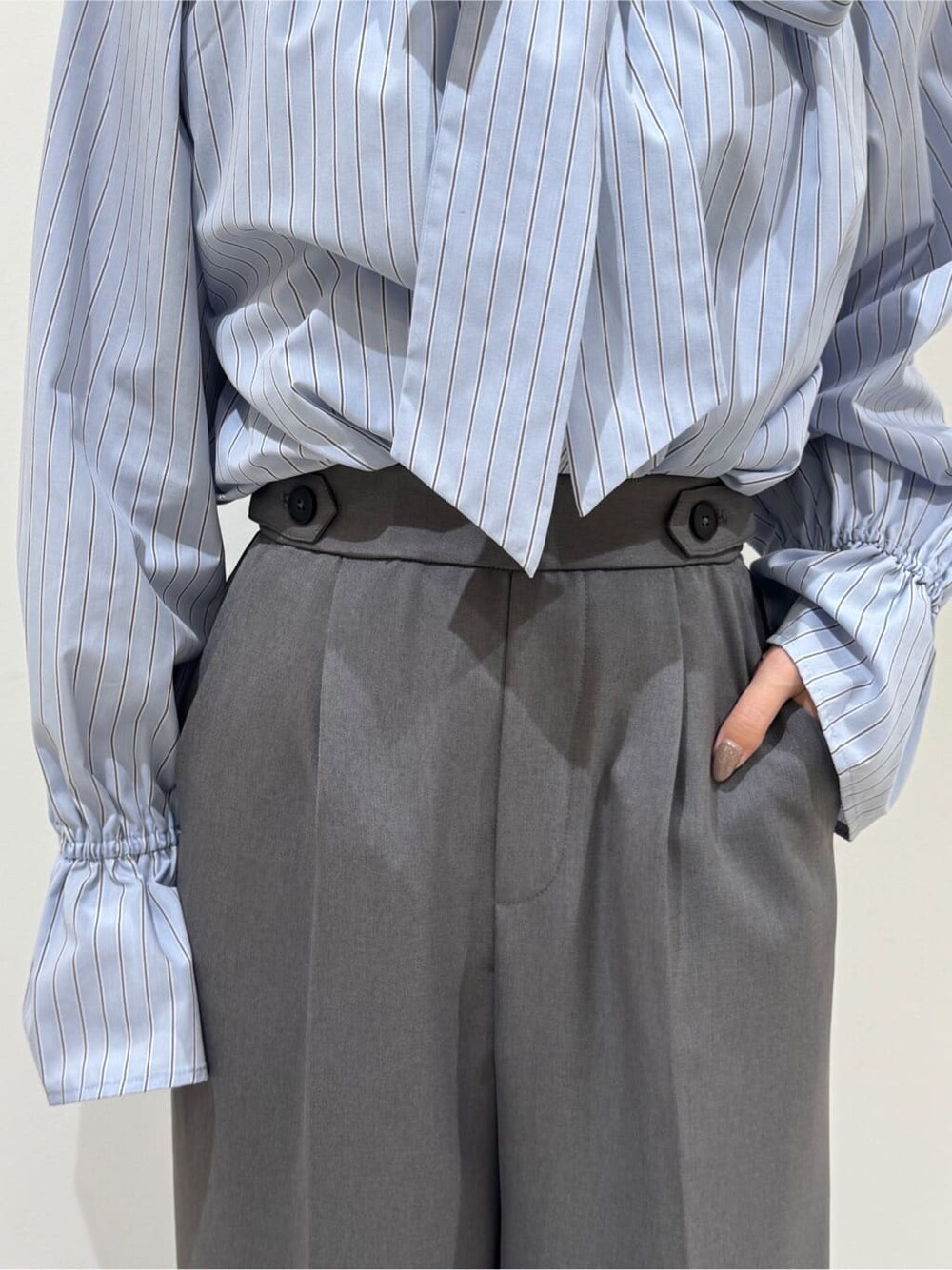 ベージュ系のステンカラーコート、ブルー系のシャツ/ブラウス、グレー系のその他パンツを着用したレディースの春コーディネートの8枚目の写真