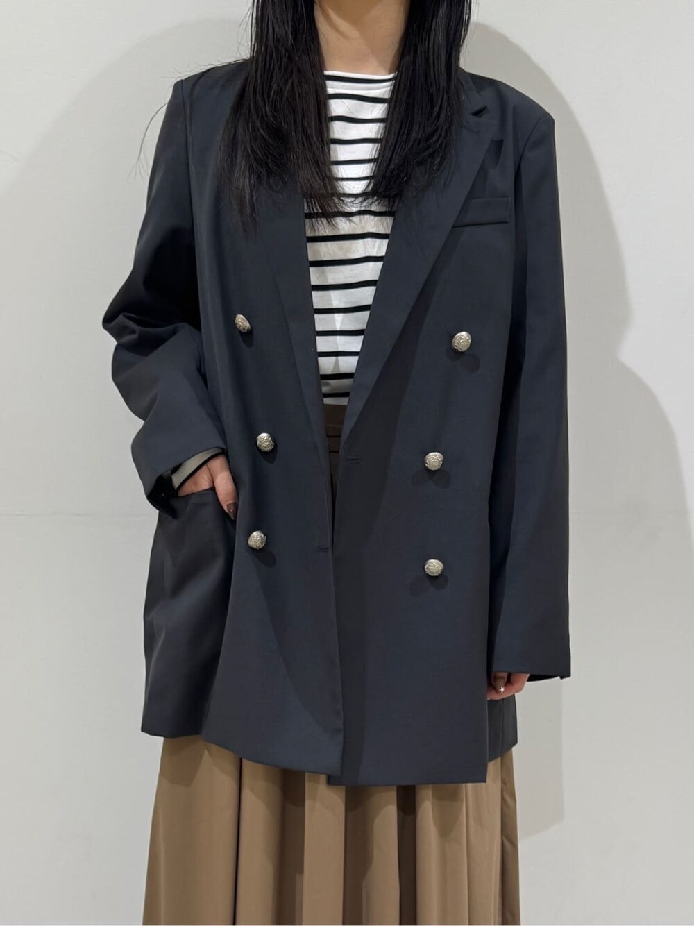 グレー系のテーラードジャケット、ブルー系のTシャツ/カットソー、ブラウン系のスカートを着用したレディースの春コーディネートの5枚目の写真