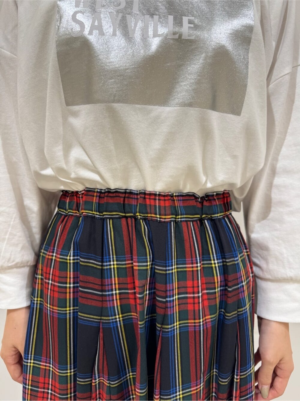 ホワイト系のTシャツ/カットソー、ブルー系のベスト、ブラック系のスカートを着用したレディースの秋コーディネートの6枚目の写真