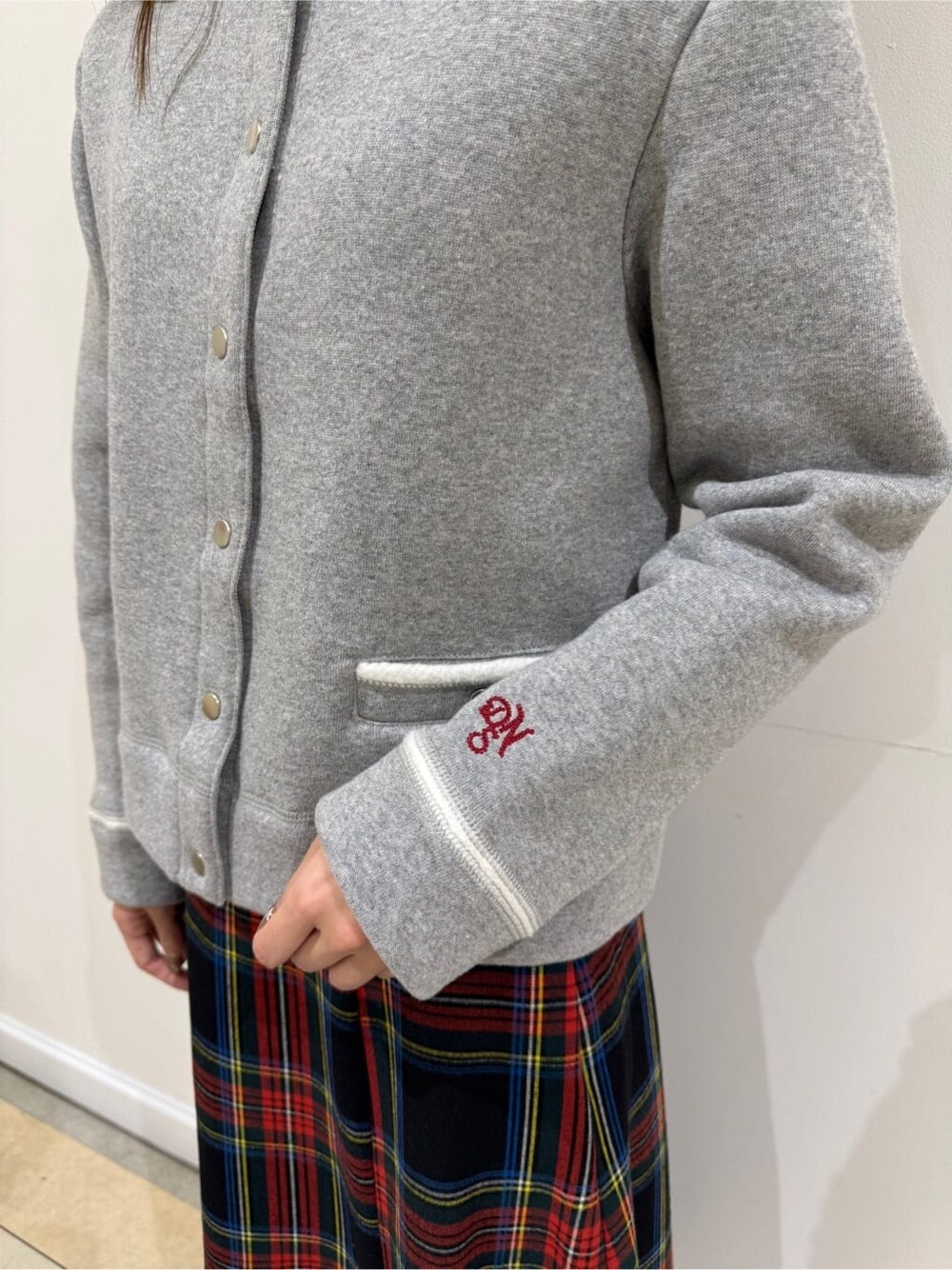 グレー系のカーディガン/ボレロ、レッド系のスカート、ブラック系のブーツを着用したレディースの冬コーディネートの6枚目の写真