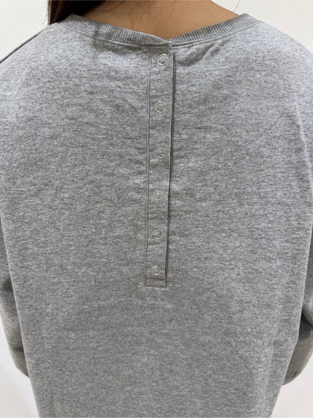 グレー系のTシャツ/カットソー、ブラック系のスカート、ブラック系のブーツを着用したレディースの秋コーディネートの6枚目の写真