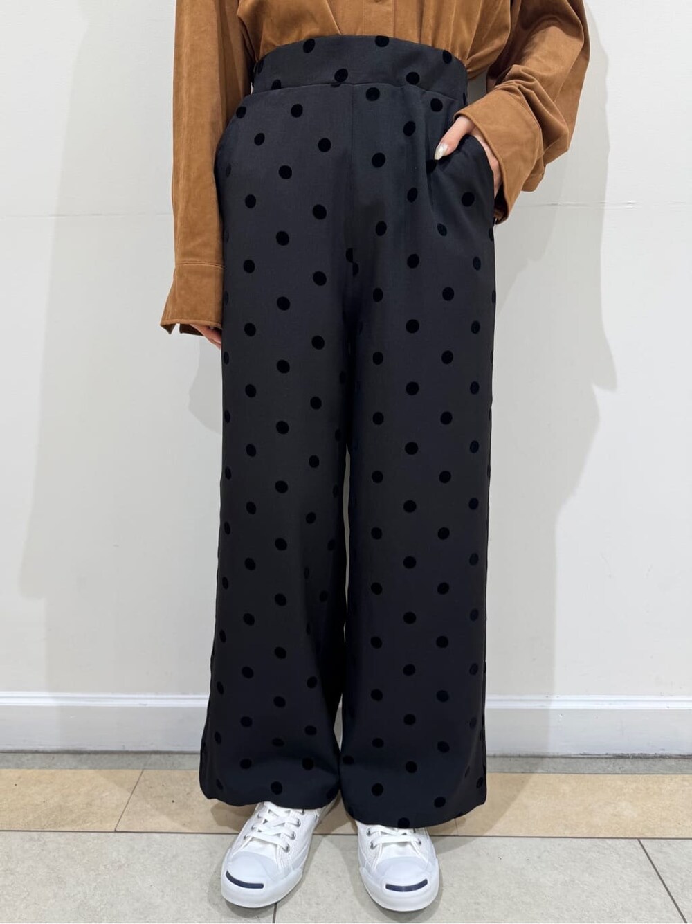 イエロー系のシャツ/ブラウス、ブラック系のその他パンツ、ブルー系のキャップを着用したレディースの秋コーディネートの6枚目の写真