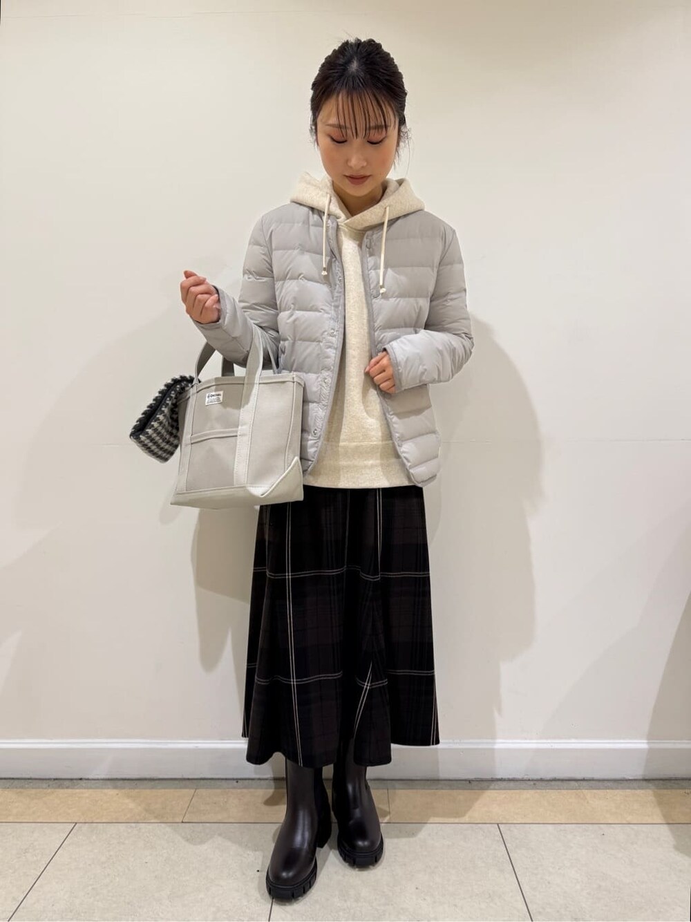ベージュ系のスウェット、グレー系のトートバッグを着用したレディースの冬コーディネートの2枚目の写真