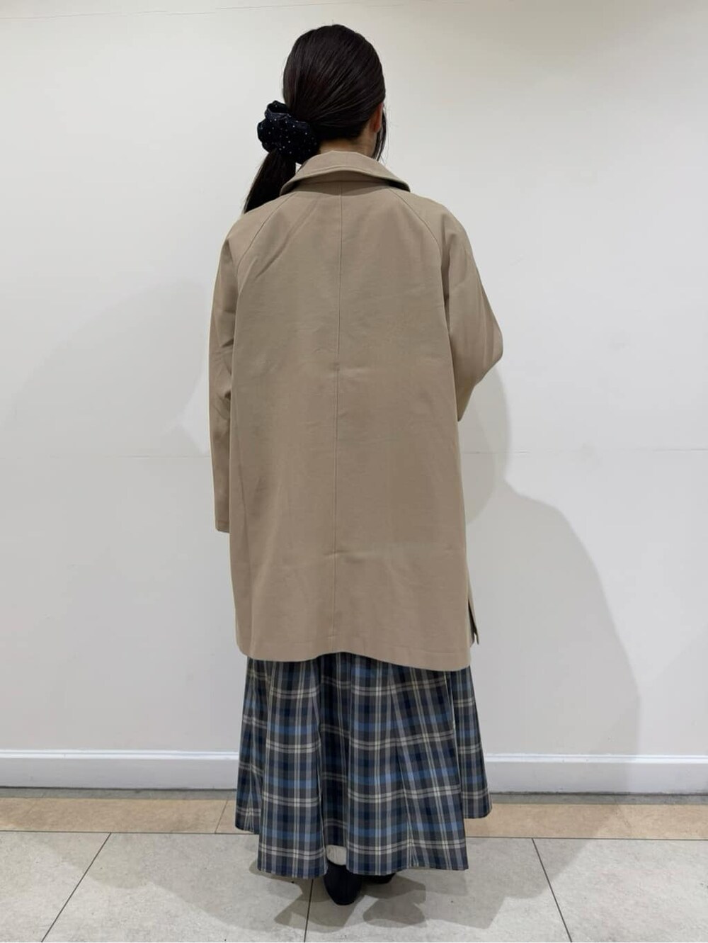 ベージュ系のステンカラーコート、ブルー系のシャツ/ブラウス、グレー系のその他パンツを着用したレディースの春コーディネートの4枚目の写真