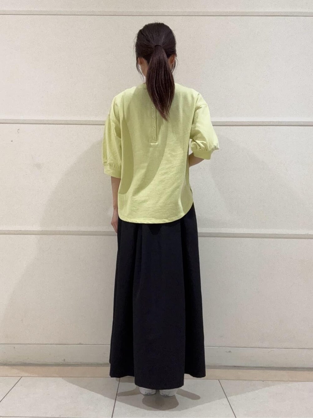 イエロー系のTシャツ/カットソー、ホワイト系のスニーカー、ホワイト系のショルダーバッグを着用したレディースの夏コーディネートの4枚目の写真