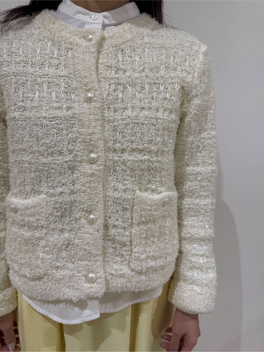 ホワイト系のカーディガン/ボレロ、ホワイト系のシャツ/ブラウス、イエロー系のスカートを着用したレディースの冬コーディネートの5枚目の写真