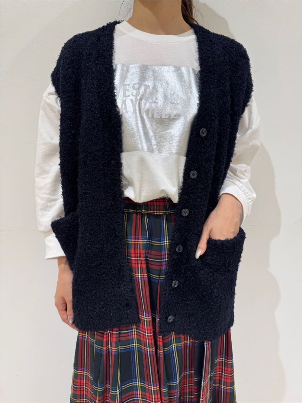 ホワイト系のTシャツ/カットソー、ブルー系のベスト、ブラック系のスカートを着用したレディースの秋コーディネートの5枚目の写真