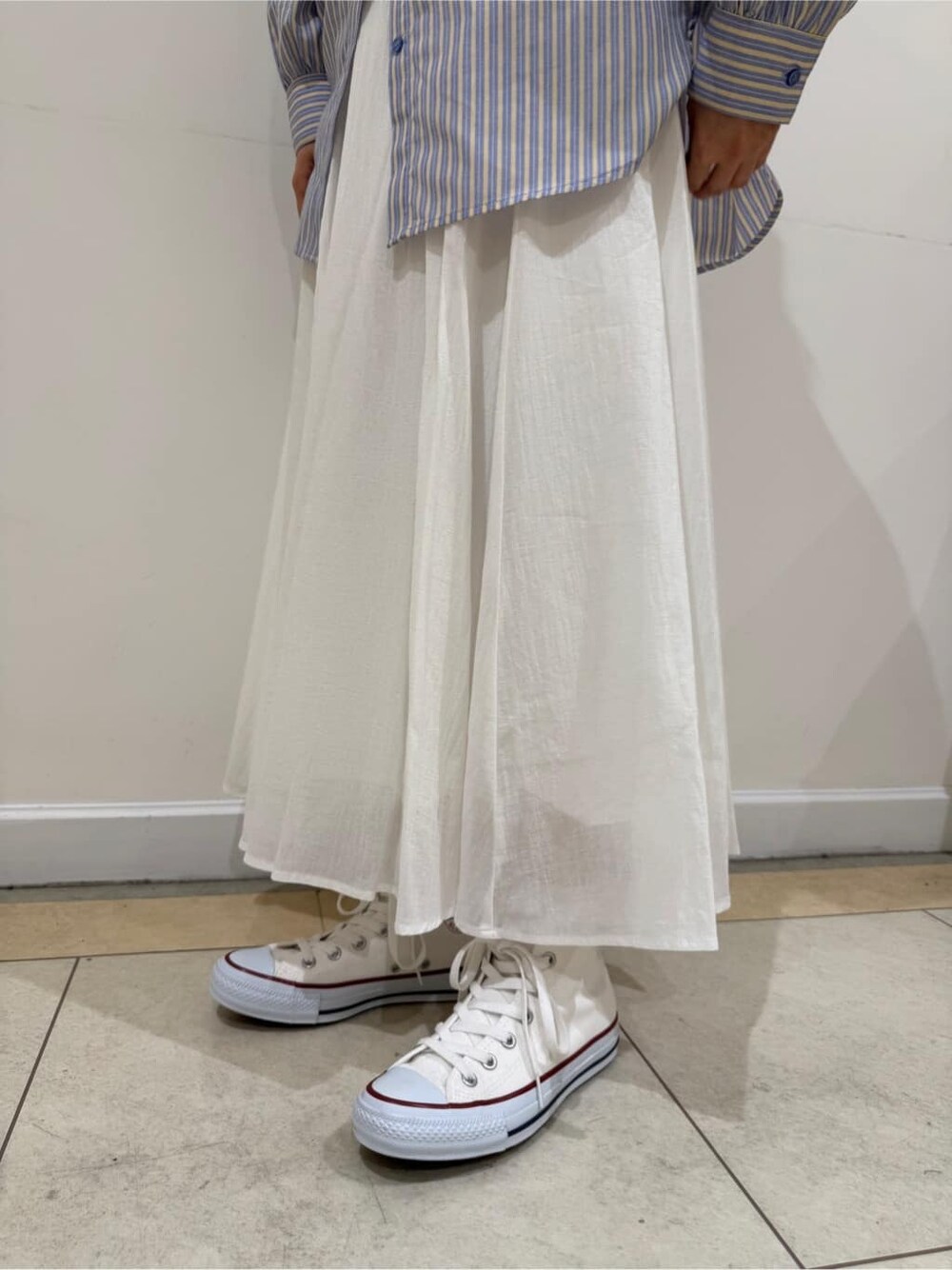 イエロー系のシャツ/ブラウス、ホワイト系のスカートを着用したレディースの夏コーディネートの7枚目の写真