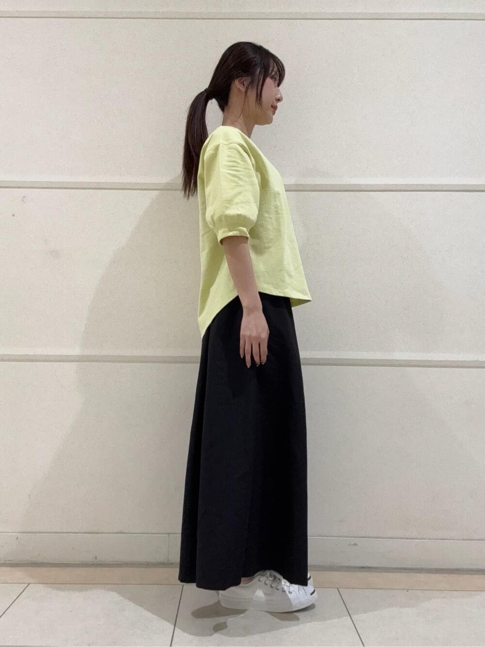 イエロー系のTシャツ/カットソー、ホワイト系のスニーカー、ホワイト系のショルダーバッグを着用したレディースの夏コーディネートの3枚目の写真
