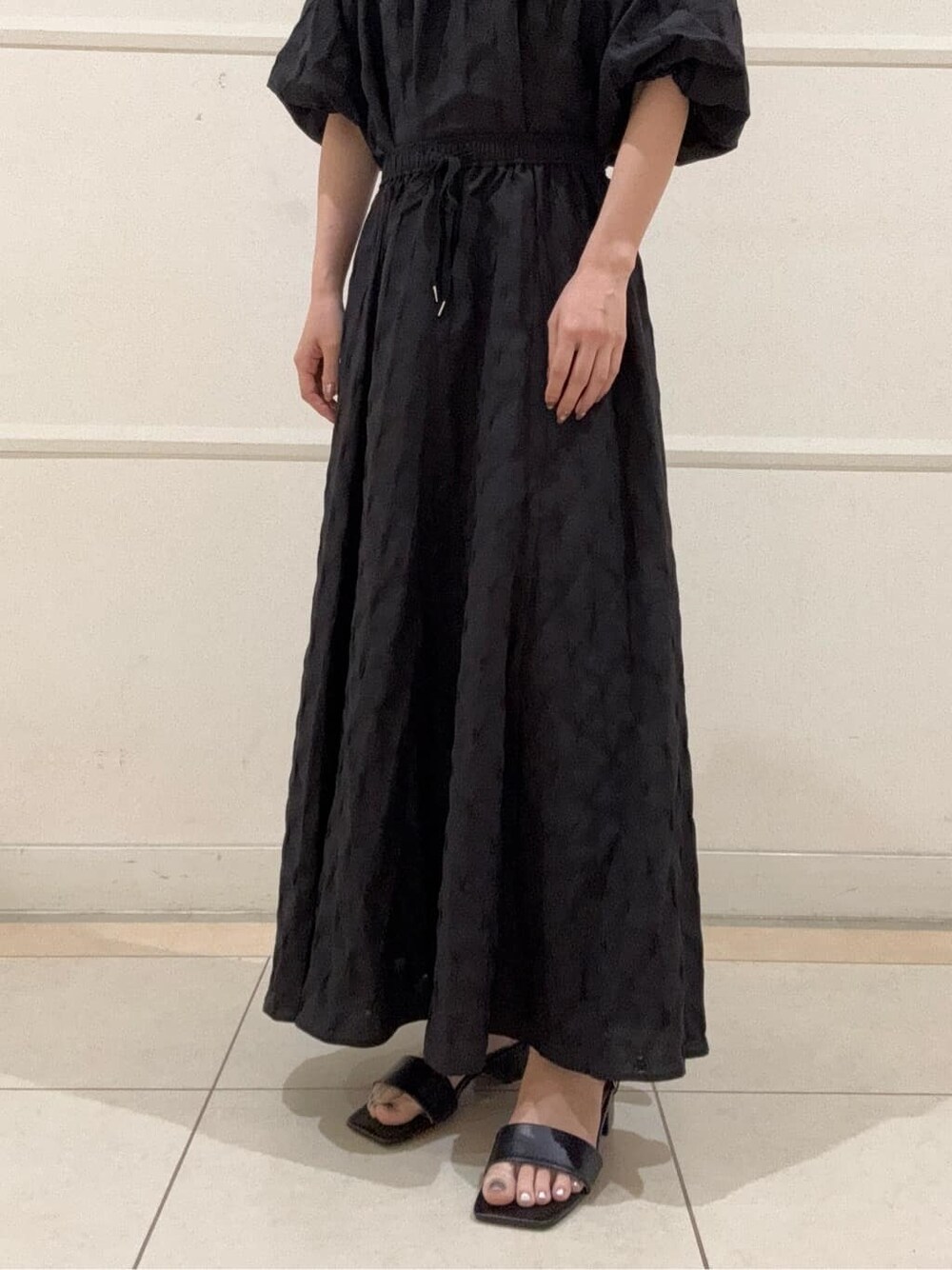 ブラック系のシャツ/ブラウス、ブラック系のスカート、ブラック系のサンダルを着用したレディースの夏コーディネートの6枚目の写真